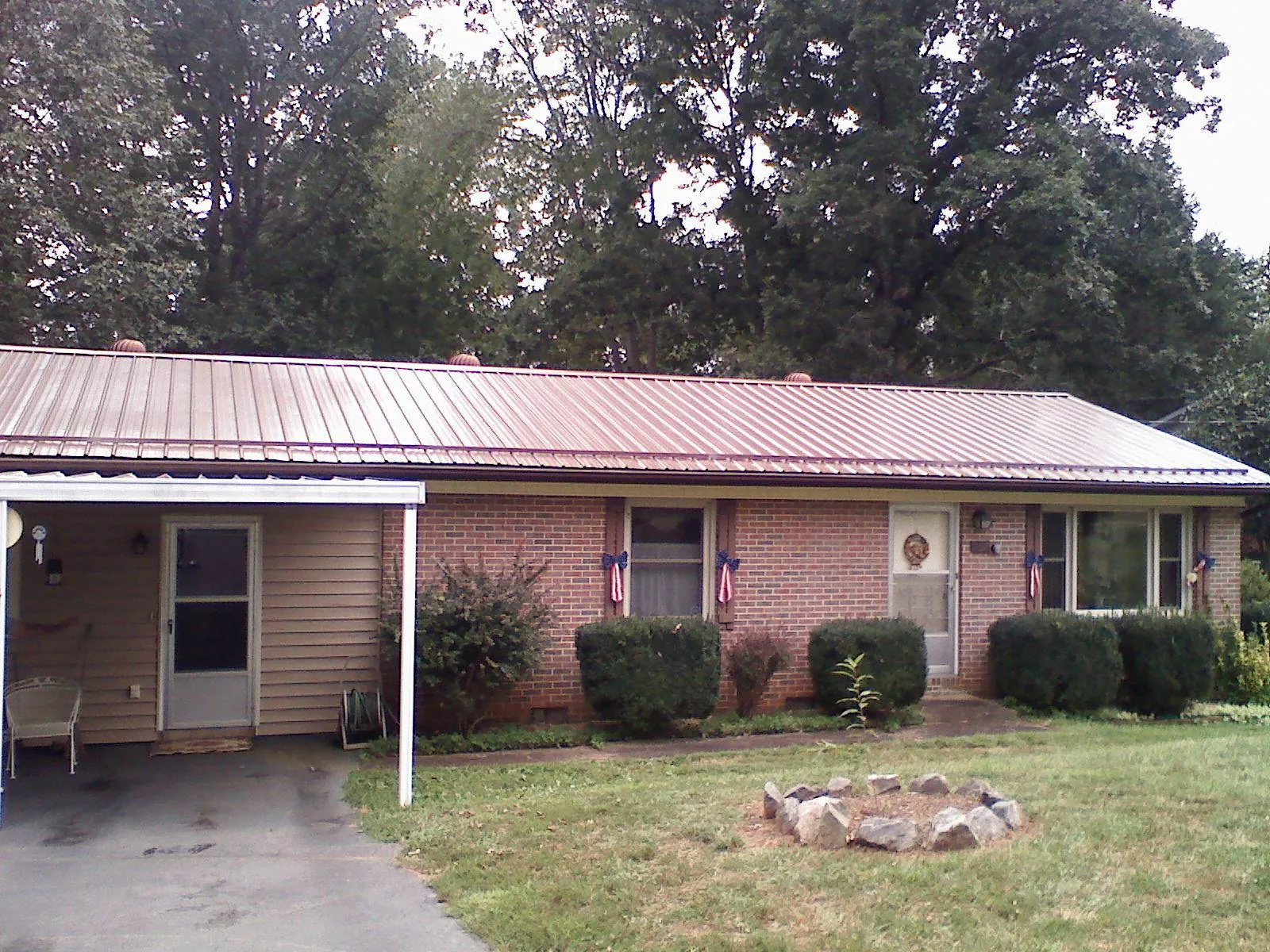 Bronze metal roof and carport on a brick ranch home — Roof Repair work by our crew in Cameron